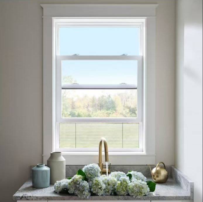 Vertical sliding window above a kitchen sink in a bright residential interior
